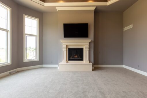 Grand Haven bedroom with fireplace and tall windows