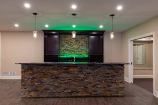 Rivendell lower-level bar with stacked stone and accent lighting