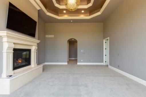 Grand Haven bedroom with fireplace and tray ceiling
