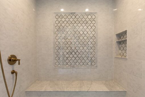 Grand Haven walk-in shower with mosaic tile panel