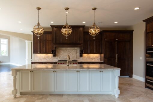 Grand Haven kitchen island with white cabinetry and dark wood range wall