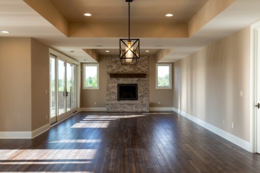 Grand Haven lower-level family room with stone fireplace and chandelier