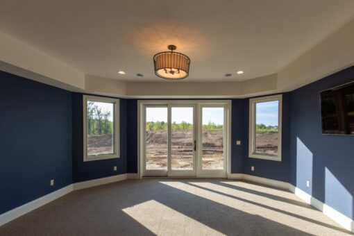 Grand Haven primary bedroom with bay of windows and navy walls