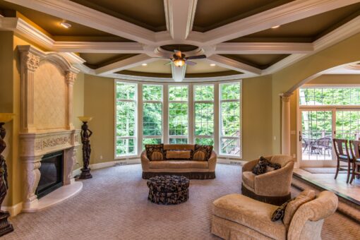 Brandywine great room with coffered ceiling and carved stone fireplace