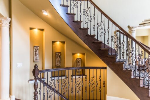 Brandywine staircase with iron railing and lit niches