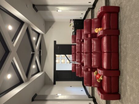 Shire home theater with red recliner seating and screen
