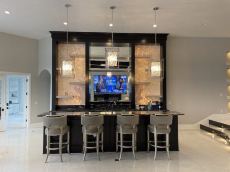 Shire lower-level bar with lit stone backsplash and bar seating