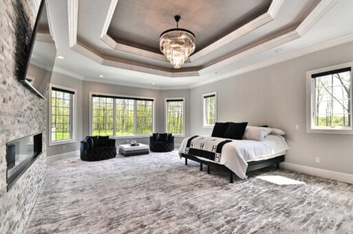 Woodland primary bedroom with tray ceiling and chandelier