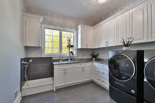 Woodland laundry room with white cabinetry