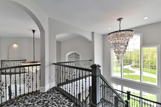 Woodland staircase with iron railing and chandelier