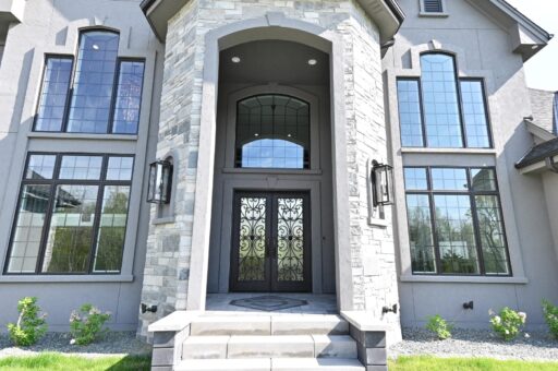 Woodland stone entry with arched iron double doors