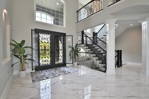 Woodland foyer staircase with iron railing and entry doors