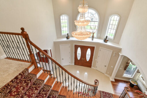 Benington two-story foyer with chandelier viewed from the balcony