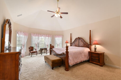 Benington primary bedroom with tray ceiling and ceiling fan