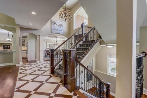 Talon foyer staircase with iron railing and patterned floor
