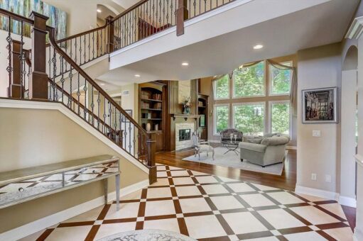 Talon foyer with patterned marble floor and staircase