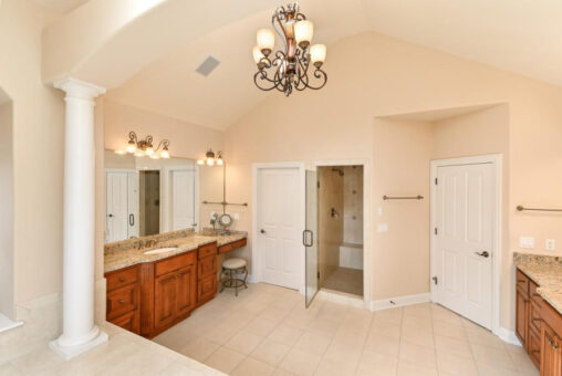 Benington primary bath with columns and chandelier