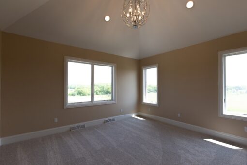 Stone Creek bedroom with windows and chandelier