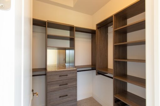 Stone Creek walk-in closet with wood-tone built-ins