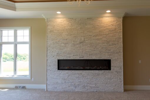 Stone Creek bedroom with stacked stone linear fireplace