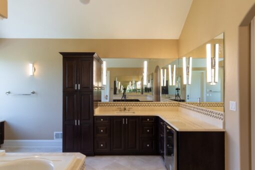 Stone Creek primary bath dark wood vanities and linen cabinet