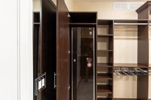 Stone Creek walk-in closet with dark wood shelving