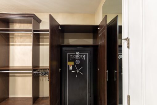 Stone Creek walk-in closet with dark wood built-ins