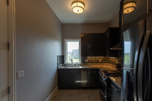 Stone Creek kitchen with dark cabinetry and window