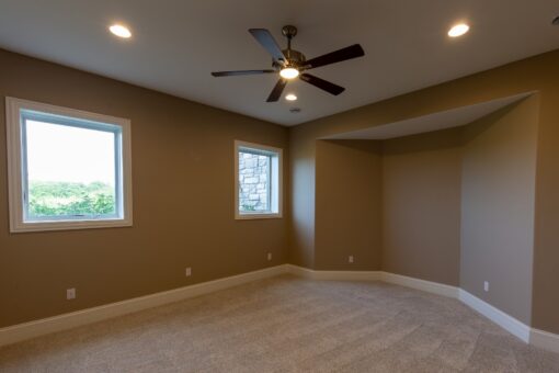 Stone Creek bedroom with ceiling fan and windows