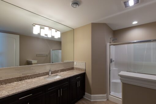 Stone Creek bathroom with dark vanity and shower
