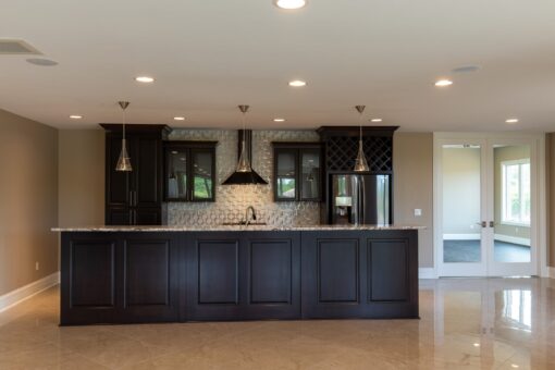 Stone Creek lower-level kitchen with dark cabinetry and range hood