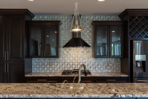 Stone Creek lower-level kitchen with mosaic backsplash and range hood