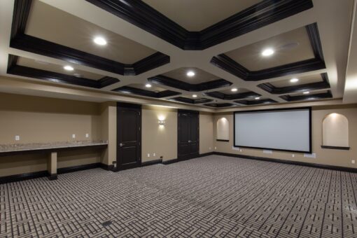 Stone Creek home theater with coffered ceiling and screen