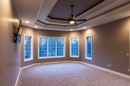 Kingfogl custom home bedroom with tray ceiling and bay of windows