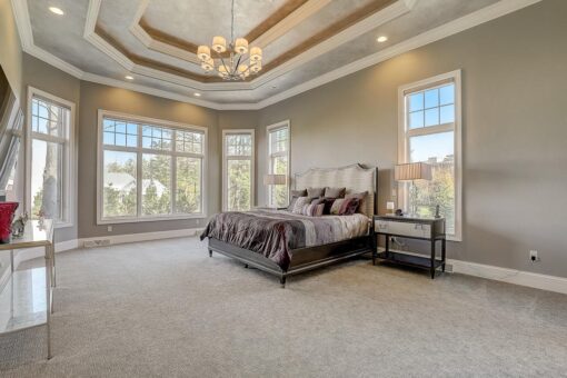 Wildwood primary bedroom with tray ceiling and window wall