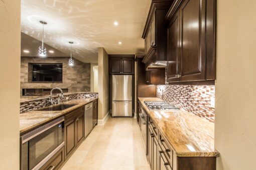 Presidio lower-level kitchen with dark cabinetry and mosaic backsplash