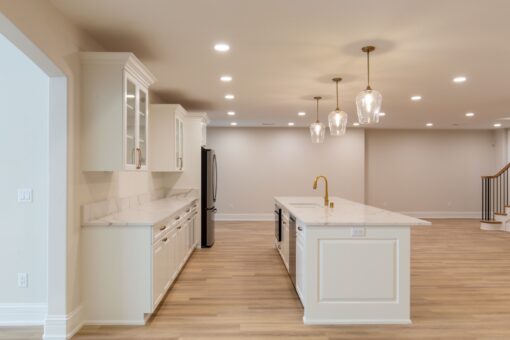 Oriole lower-level kitchen with white cabinetry and pendants