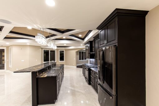 Saddlebrook lower-level kitchen with dark cabinetry and chandeliers
