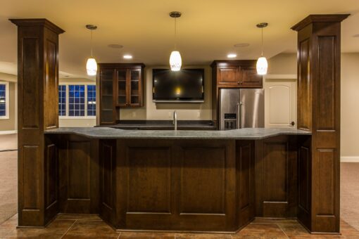 Kingfogl custom home lower-level bar with wood columns and pendant lights