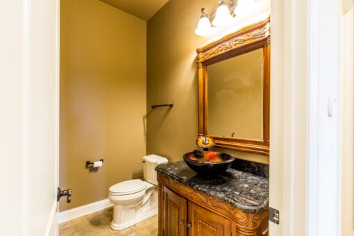Richland powder room with gold mirror and vessel sink