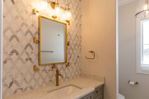 Prescott bathroom with herringbone tile and brass mirror