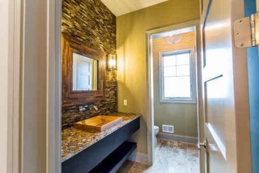 Compton powder room with stacked stone and wood vanity