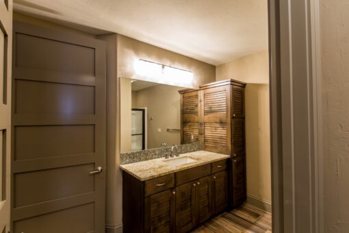 Kingfogl custom home bathroom with dark wood vanity and linen cabinet
