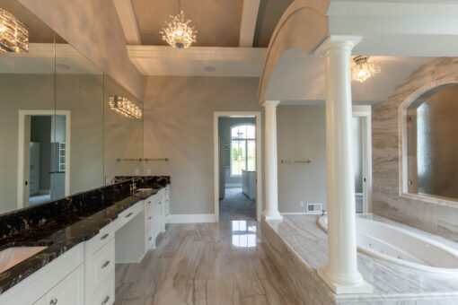 Kingfogl custom home primary bath double vanity with dark granite and columned tub alcove