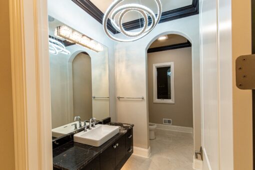 Saddlebrook bathroom with dark vanity and arched mirror