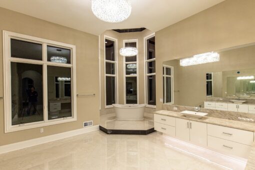 Kingfogl custom home primary bath with crystal chandelier, bay window and white vanity