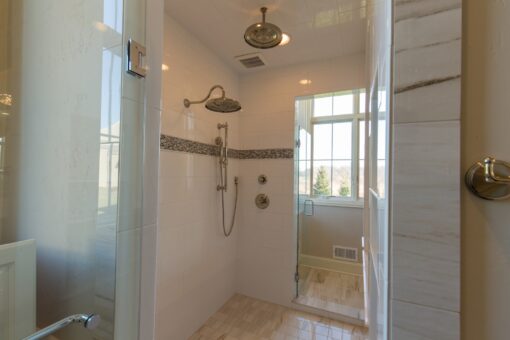 Kingfogl custom home walk-in shower with rain head and mosaic accent band