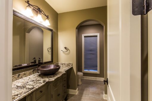Kingfogl custom home bathroom with granite vanity, vessel sink and arched niche