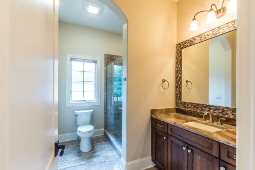 Kingfogl custom home bathroom with dark wood vanity and framed mirror