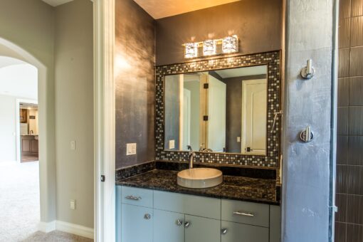 Kingfogl custom home bathroom with mosaic-framed mirror and vessel sink